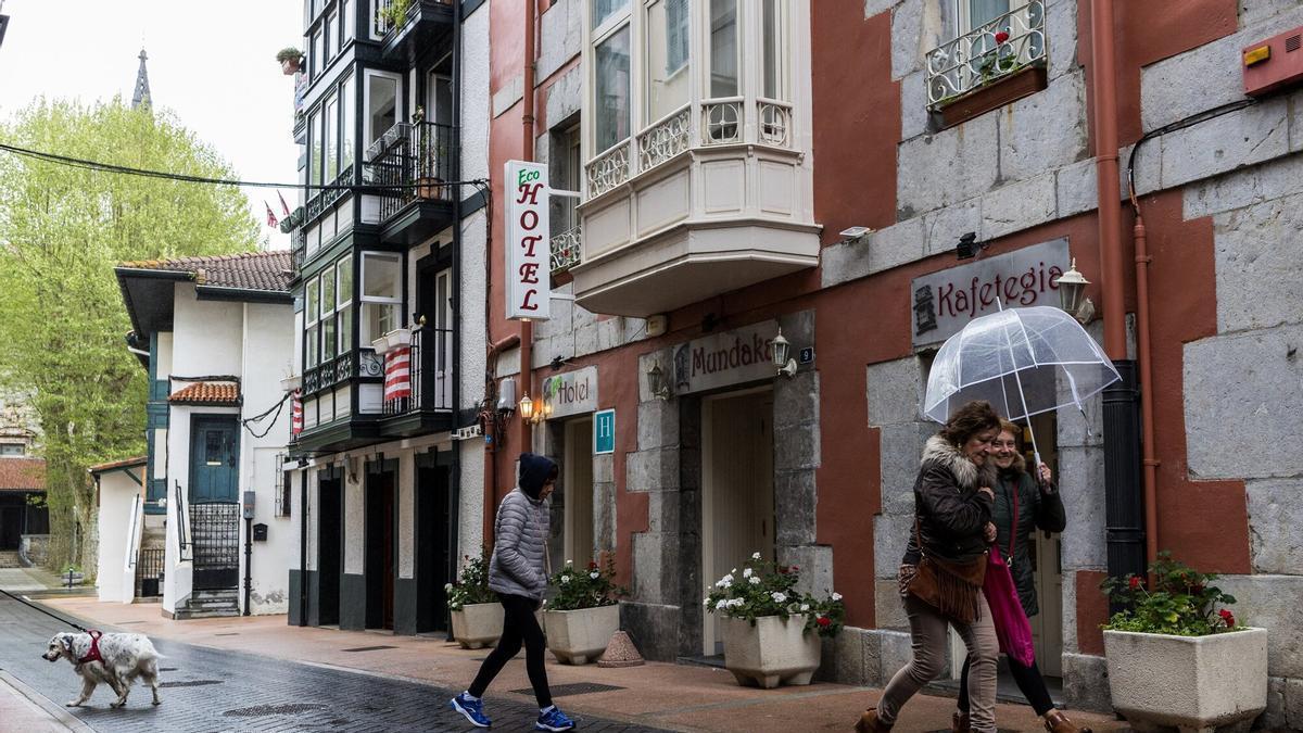 Personas paseando por las calles empedradas de Mundaka.