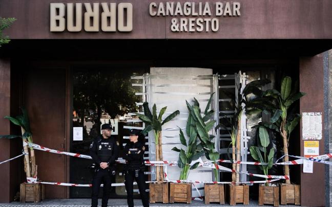 Agentes de la Policía Nacional, frente al restaurante incendiado.