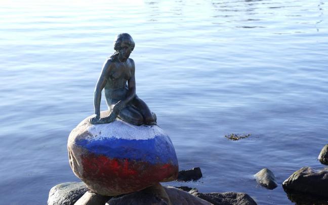 La escultura de La Sirenita, con los colores de la bandera rusa.