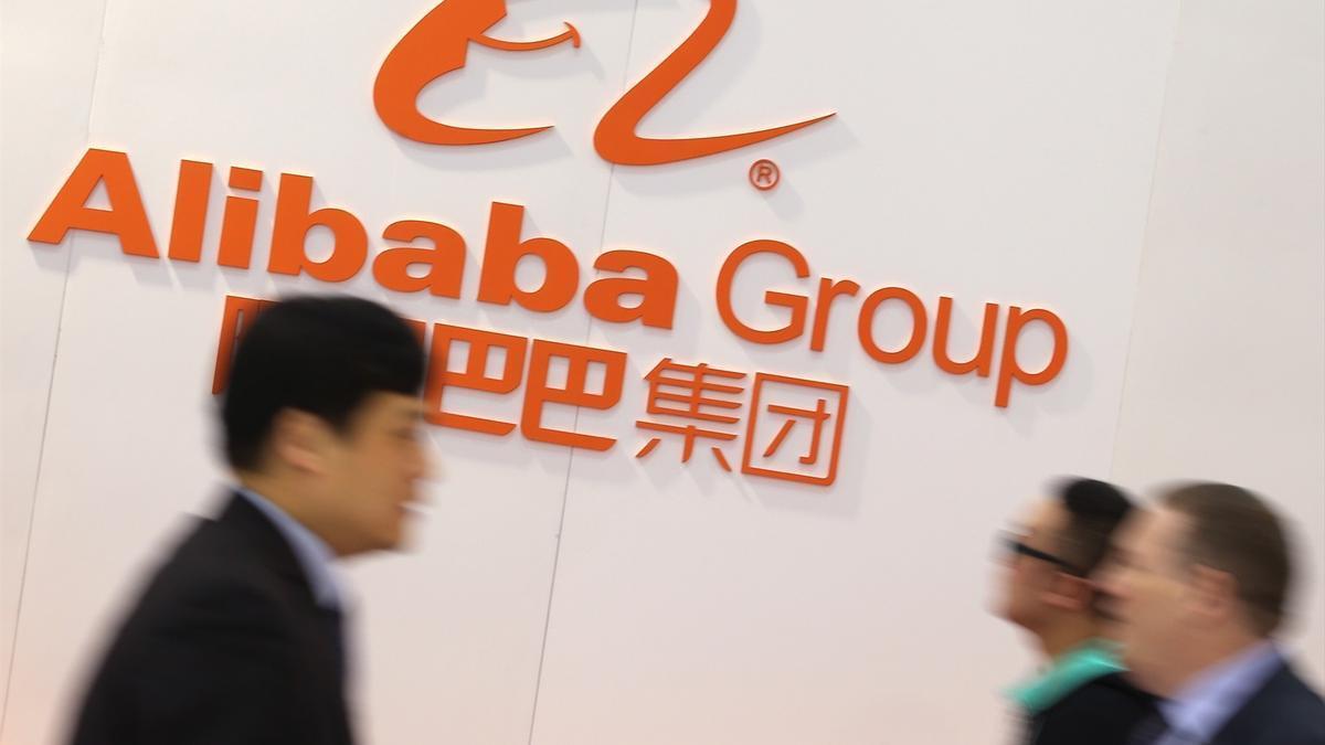 La gente pasa junto al logotipo del grupo chino de Internet Alibaba Group durante la inauguración de CeBIT.