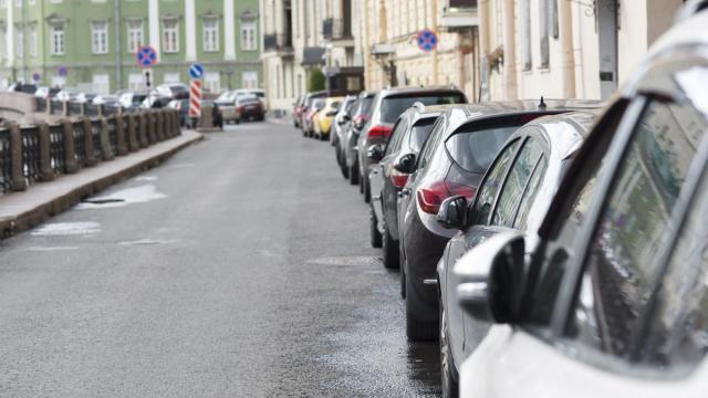 Coches aparcados en línea en una calle.