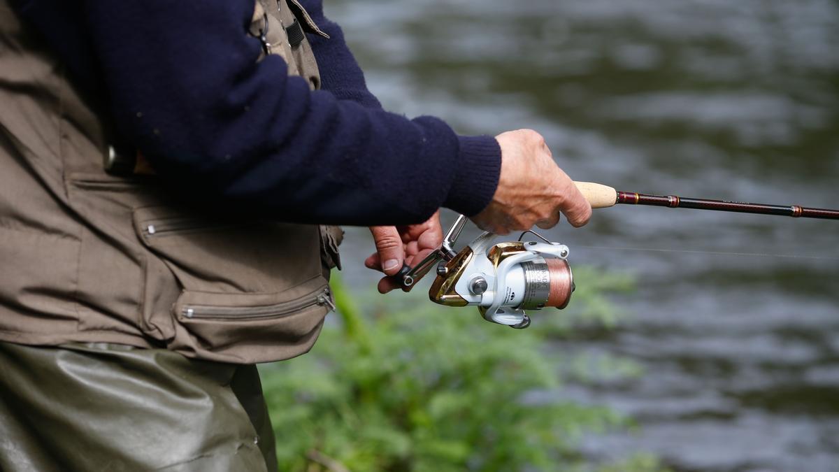 Detalle de la caña de pescar de un hombre durante el comienzo de la campaña de pesca de salmón