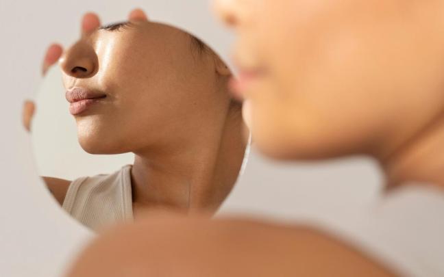 Mujer mirándose los labios tras un tratamiento.