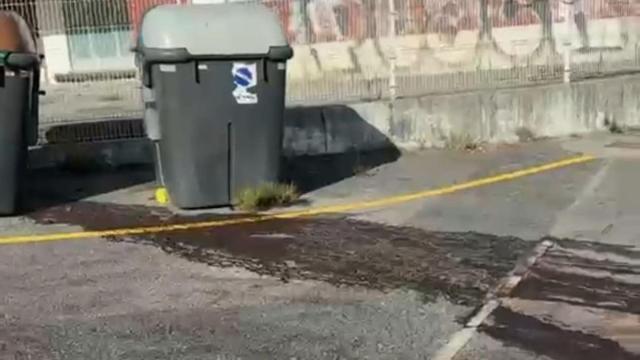 Manchas de vertidos junto a los contenedores de basura.