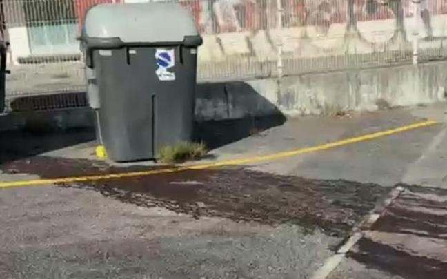 Manchas de vertidos junto a los contenedores de basura.