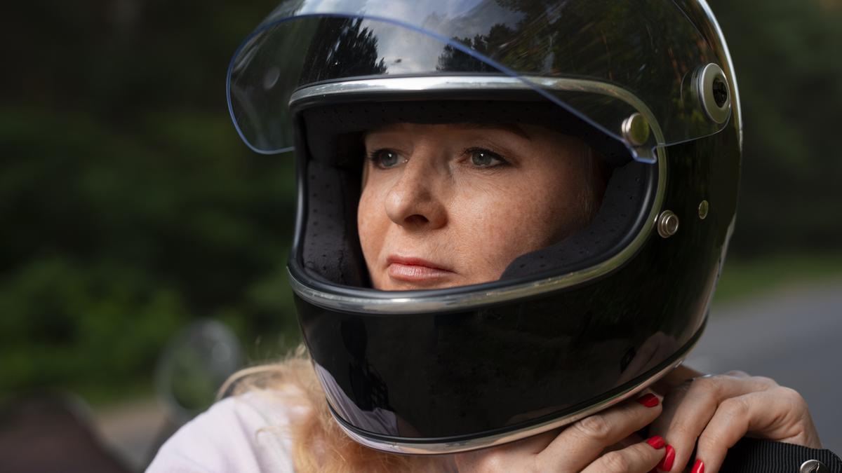 Una mujer se pone el casco.