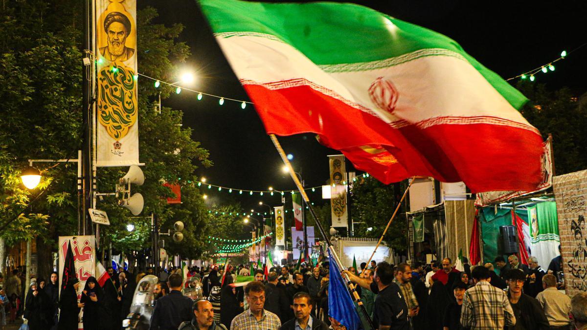 Un hombre ondea una bandera iraní.
