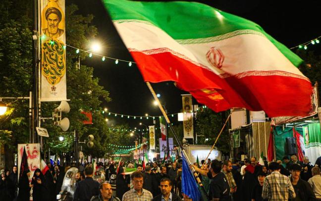 Un hombre ondea una bandera iraní.