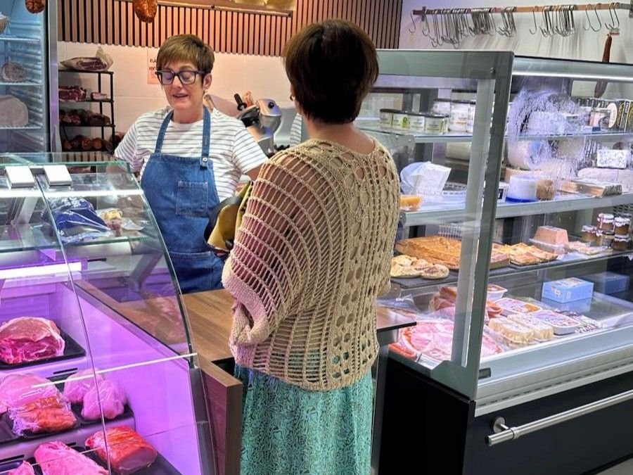 Una cliente conversa con una de las charcuteras ya instalada en la nueva Azoka Plaza de Laudio