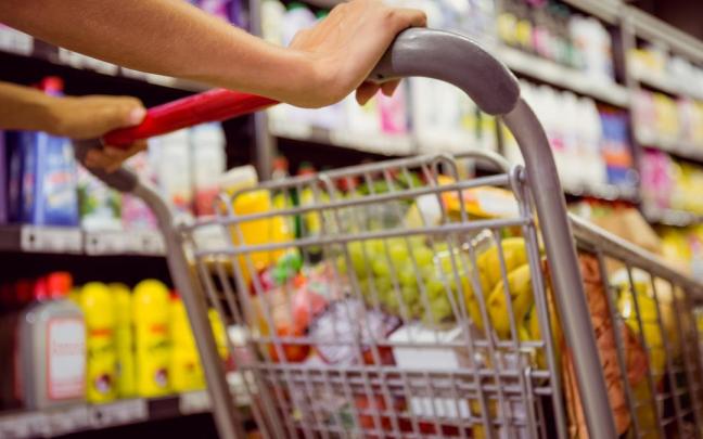 Una mujer lleva un carro de la compra.