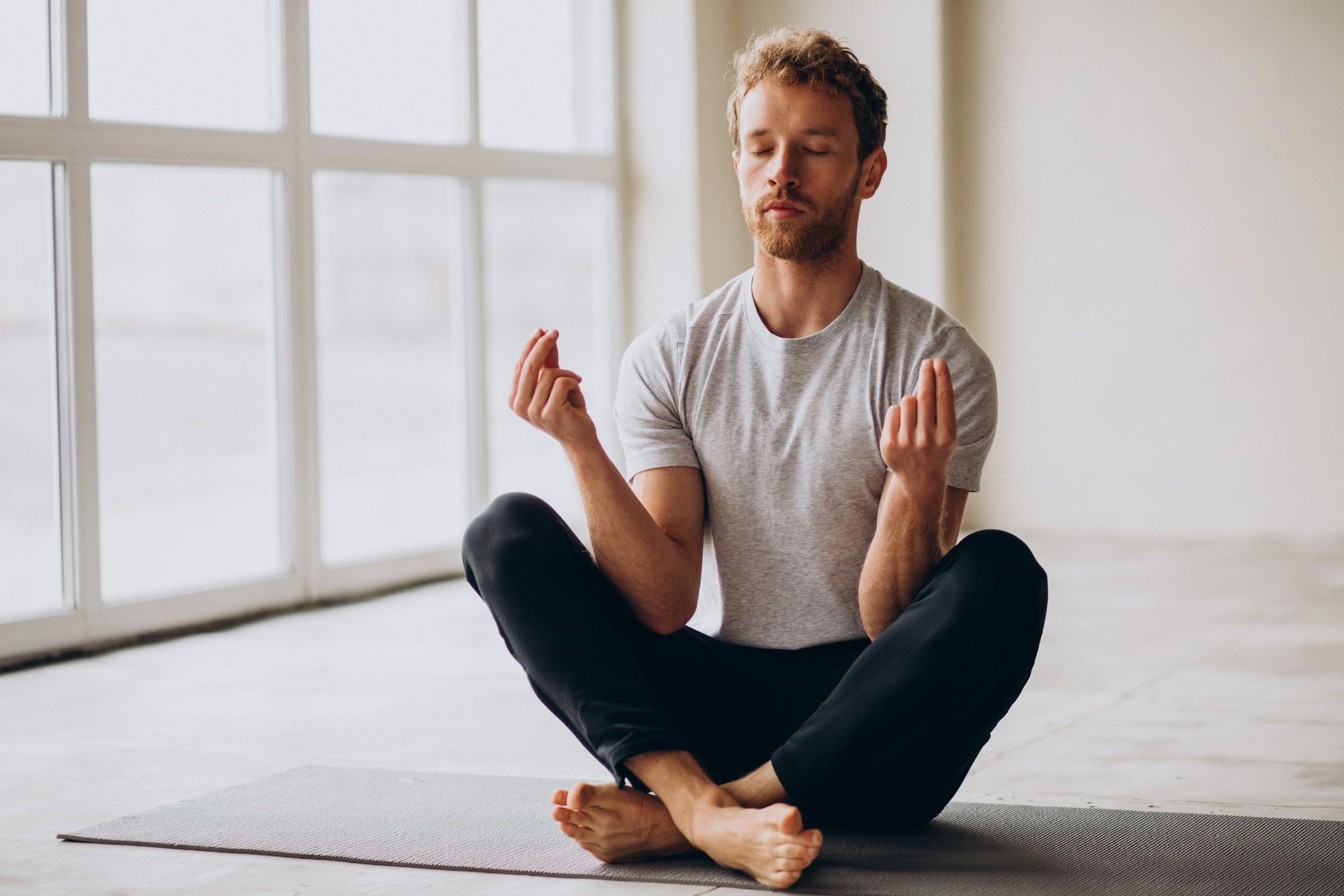 Un hombre practica meditación en casa.