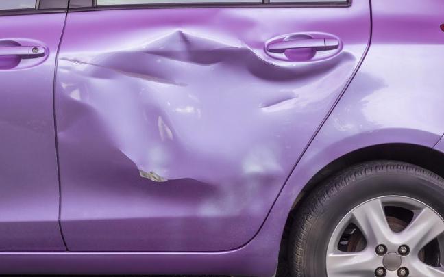 Abolladuras en la puerta trasera de un coche.