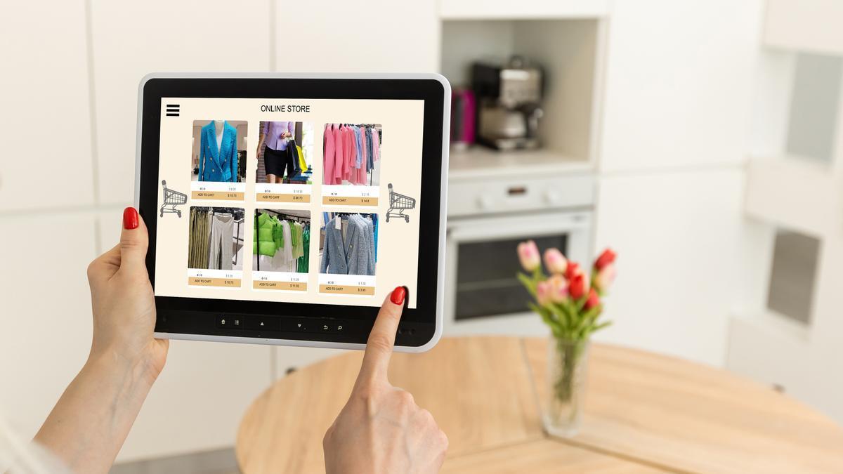 Una mujer utiliza una tablet para comprar ropa online.