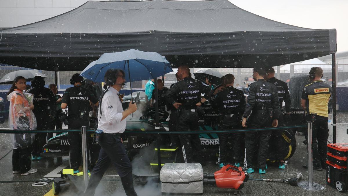 Mercedes se resguarda de la lluvia antes de tomar la salida.