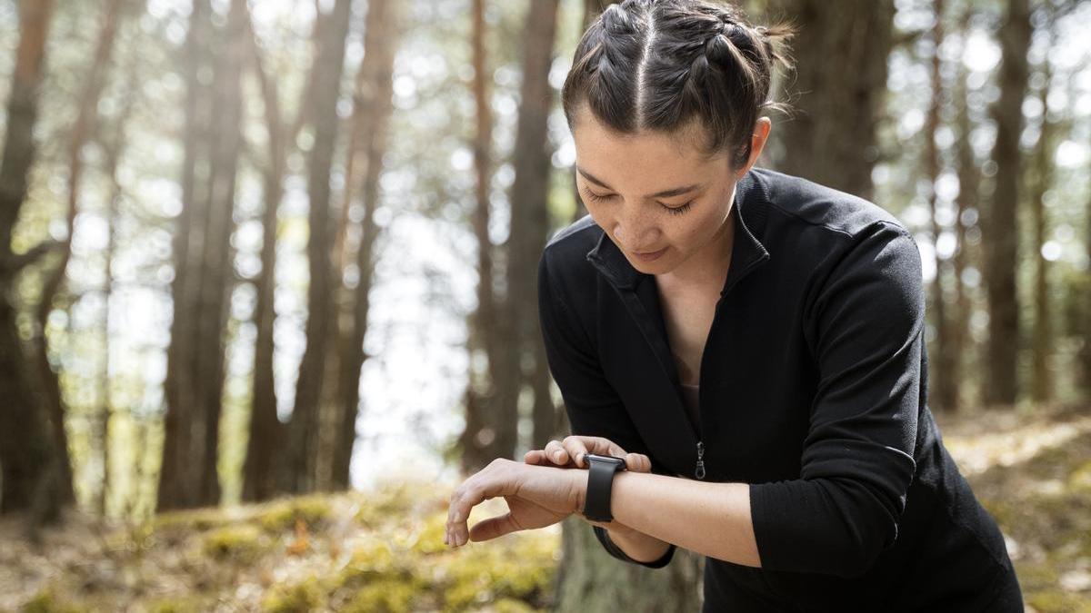Joven mira el reloj durante su caminata.