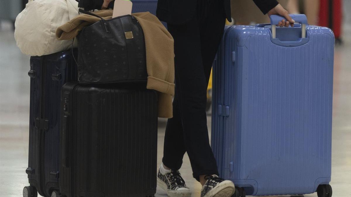 Una persona con maletas en una foto de archivo.