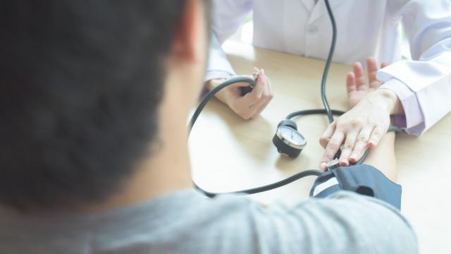 Un médico toma la tensión a su paciente.