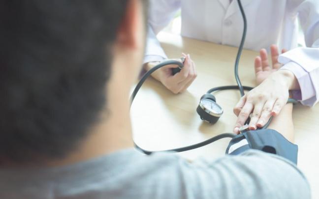 Un médico toma la tensión a su paciente.