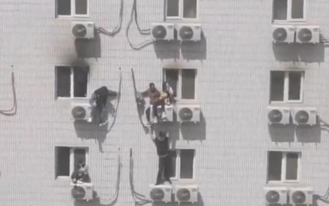 Varias personas intentan escapar de las llamas.