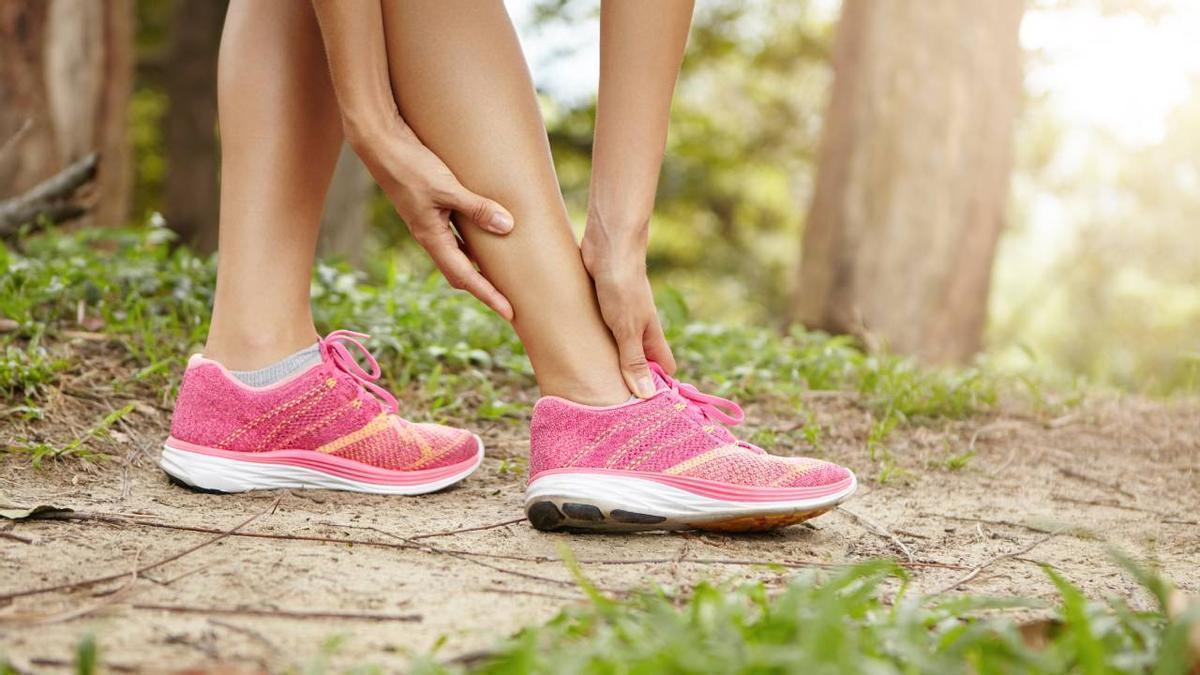 Primer plano de las manos de una deportista llevándose las manos a las piernas