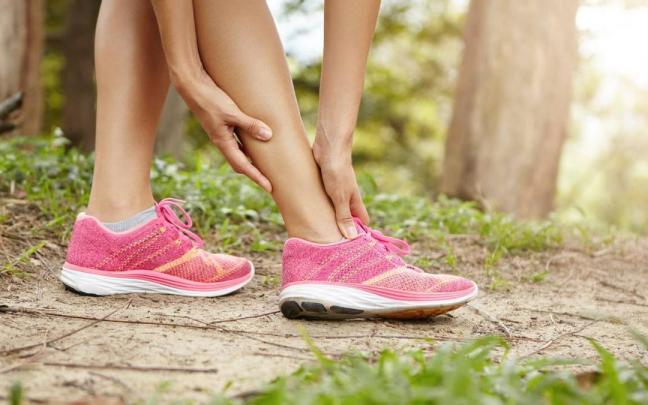 Primer plano de las manos de una deportista llevándose las manos a las piernas