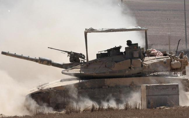 Un vehículo militar israelí maniobra cerca de la valla fronteriza con la Franja de Gaza.