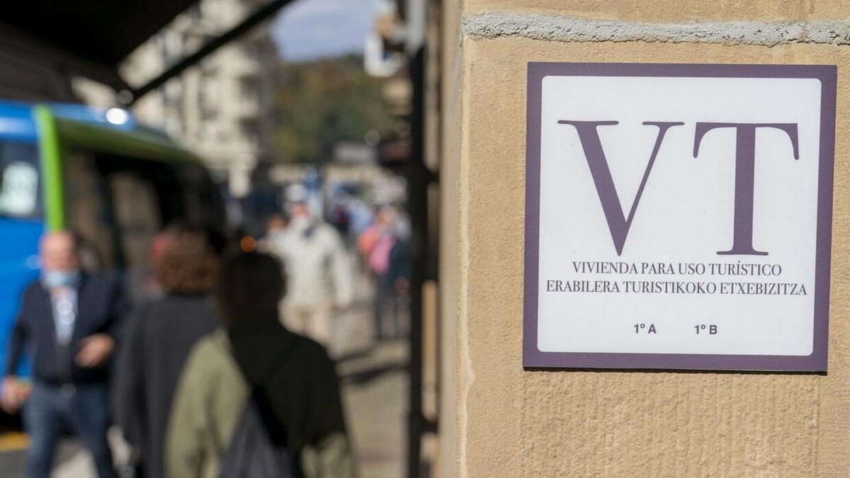 Una placa con las letras VT colocada a la entrada de un portal de Donostia para hacer ver que en la comunidad hay viviendas de uso turístico.