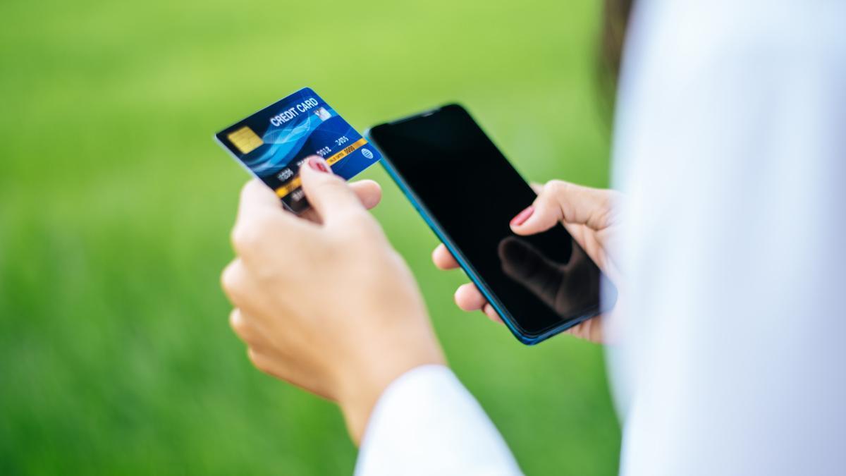 Una persona realiza un pago a través del móvil con su tarjeta.
