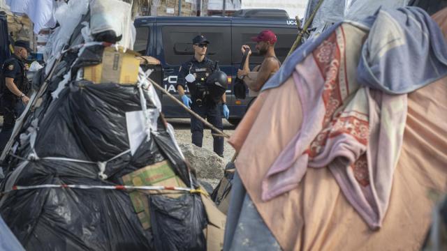 Varios agentes de Policía Nacional controlan a los migrantes en la playa del Trampolín.
