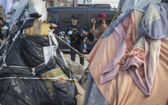 Varios agentes de Policía Nacional controlan a los migrantes en la playa del Trampolín.