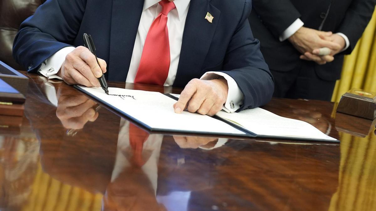 Fotografía de las manos del presidente de Estados Unidos, Donald Trump, firmando una orden ejecutiva.