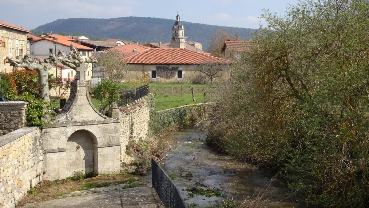 El río Omecillo nace en la localidad de Bóveda. Al fondo, la iglesia de San Vicente.