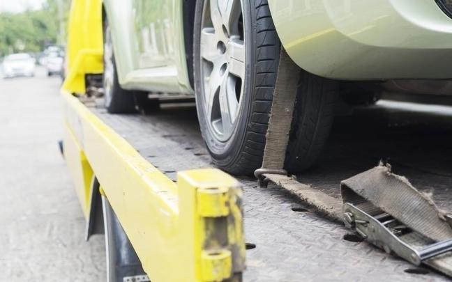 Una grúa se lleva un coche averiado.