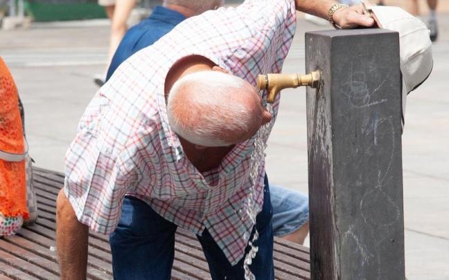Un hombre se refresca en una fuente debido al calor. / Josu Chavarri Erralde Un hombre se refresca en una fuente debido al calor.
