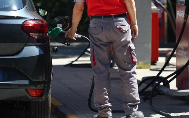 Una persona reposta gasolina en un coche, en una gasolinera.