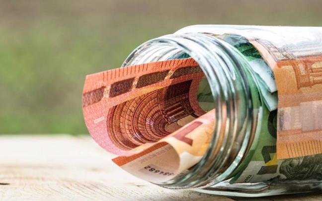 Una serie de billetes en el interior de un tarro de cristal