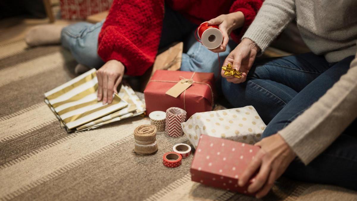 Dos personas envolviendo regalos