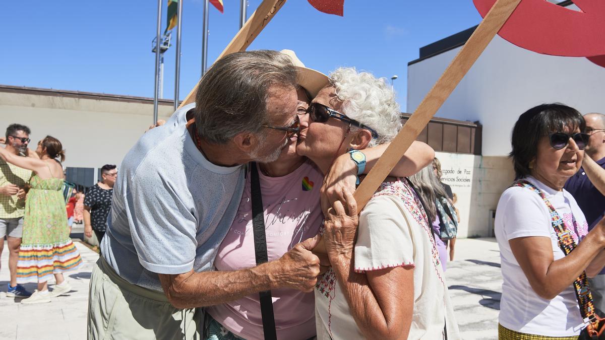 Varias personas se besan durante la quedada frente al Ayuntamiento de Bezana