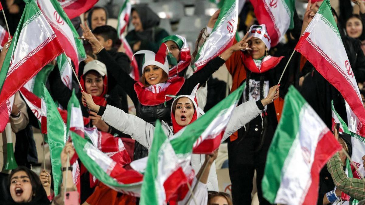 Varias mujeres iraníes animan desde las gradas a su selección.