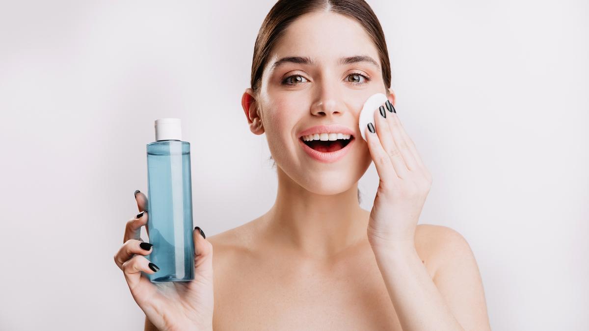 Una mujer se desmaquilla con agua micelar.