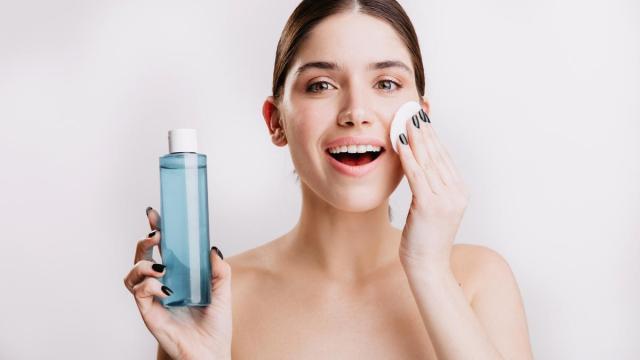 Una mujer se desmaquilla con agua micelar. Una mujer se desmaquilla con agua micelar.