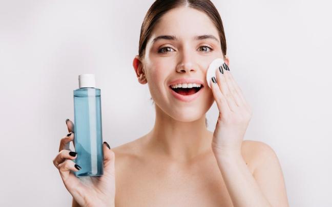 Una mujer se desmaquilla con agua micelar. Una mujer se desmaquilla con agua micelar.