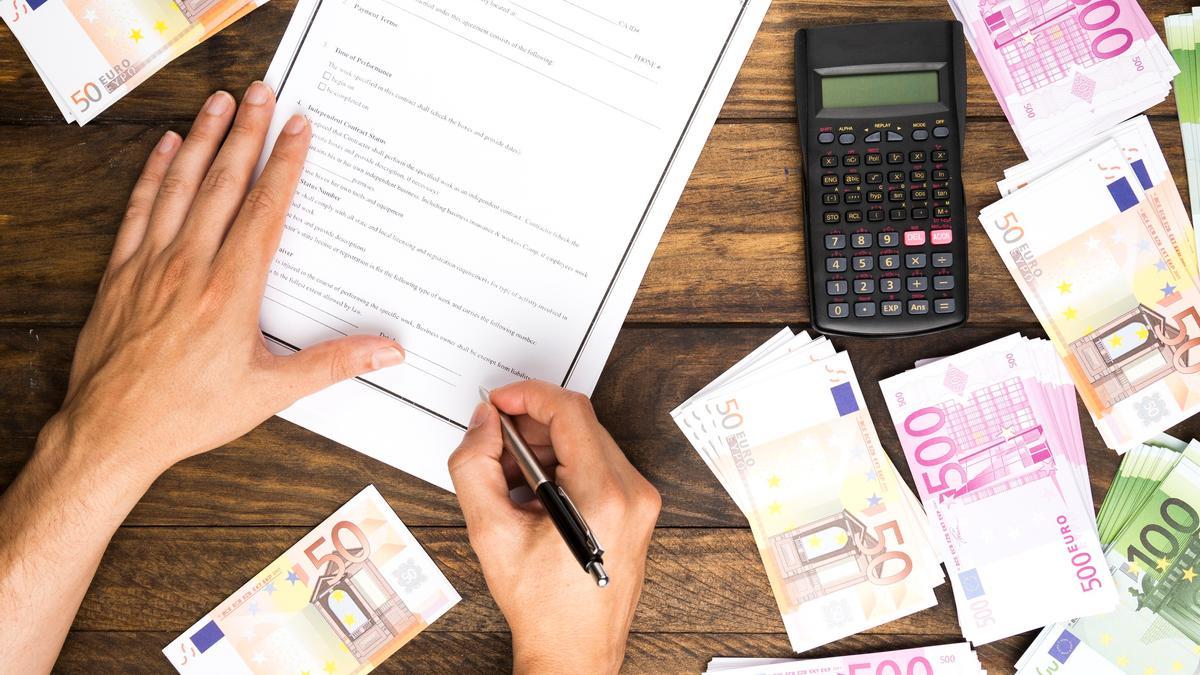 Un hombre firma el contrato de un préstamo bancario.