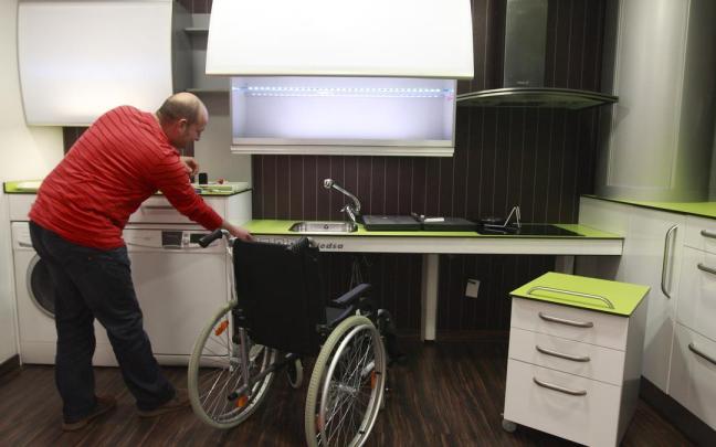Una persona en el interior de una cocina adaptada para personas con movilidad reducida