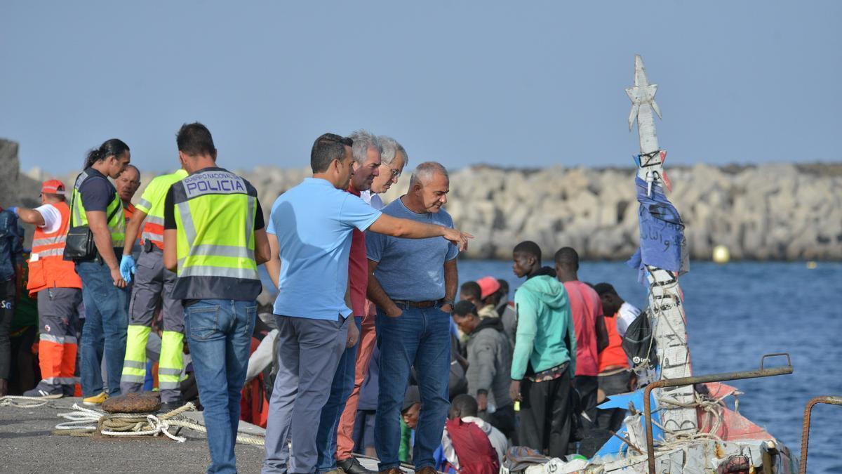 Los migrantes de una embarcación desembarcan este domingo en el puerto de El Hierro.