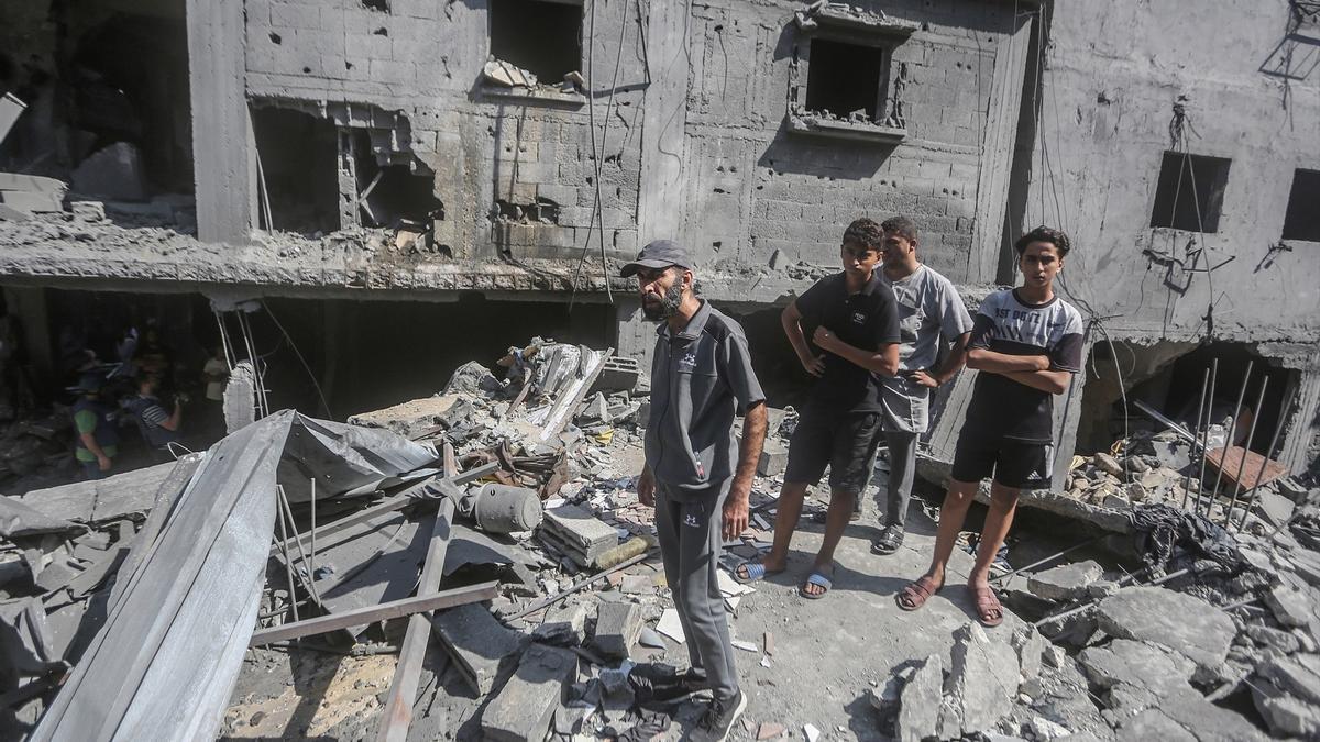 Un grupo de palestinos inspeccionan un edificio destruido por los bombardeos israelíes en Gaza.