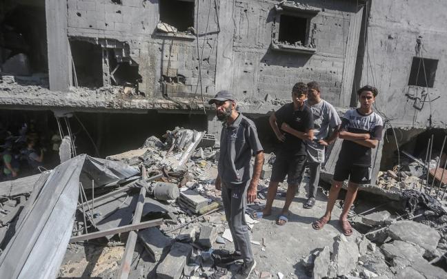 Un grupo de palestinos inspeccionan un edificio destruido por los bombardeos israelíes en Gaza.