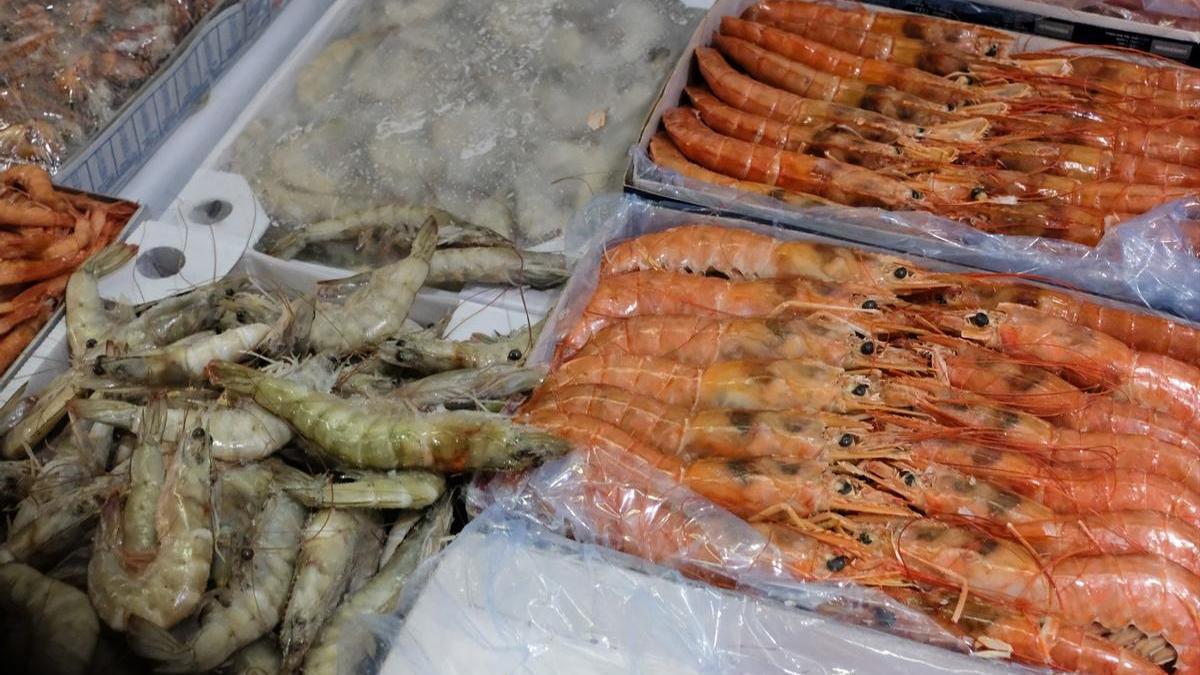 Cajas con gambas y langostinos en la sección de pescadería y mariscos de un supermercado