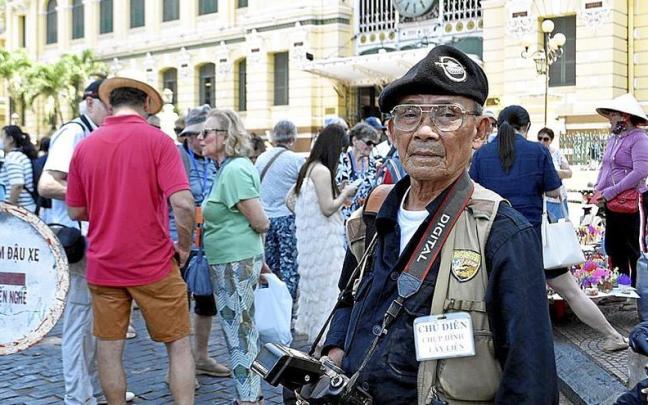 Dien, de 79 años y veterano del ejército del sur, frente a la oficina de Correos de Ho Chi Minh (Saigón), donde hace fotos a turistas. Dien, de 79 años y veterano del ejército del sur, frente a la oficina de Correos de Ho Chi Minh (Saigón), donde hace fotos a turistas.