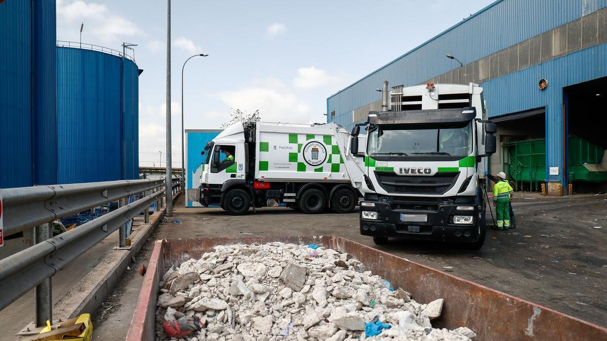 Un contenedor con escombros junto a dos camiones de basura a las puertas de Valdemingómez.